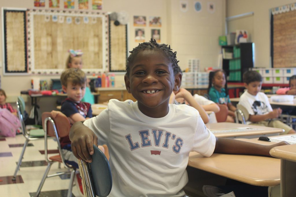 image of student smiling in classroom at Abram Lansing School