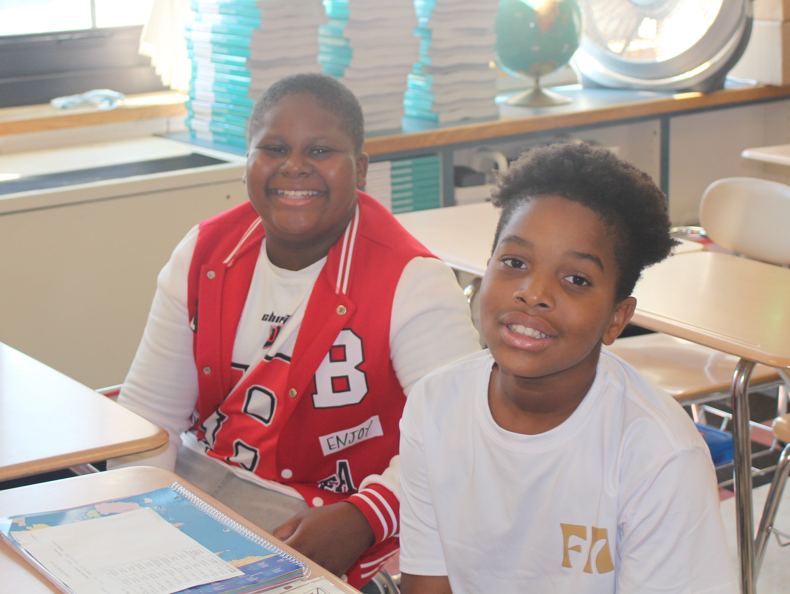 two middle school students smile