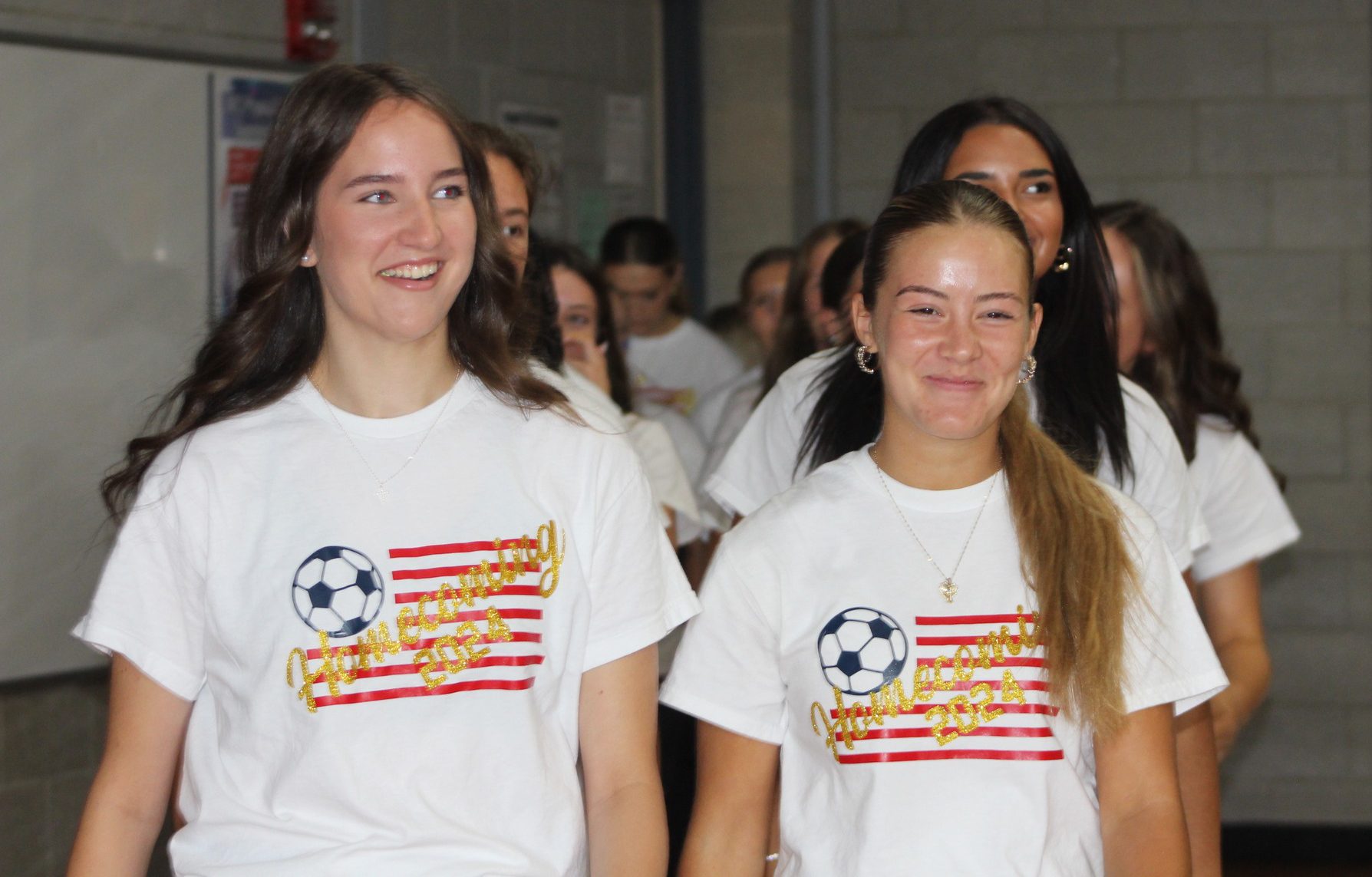 Two high school students wearing matching soccer tshirts.