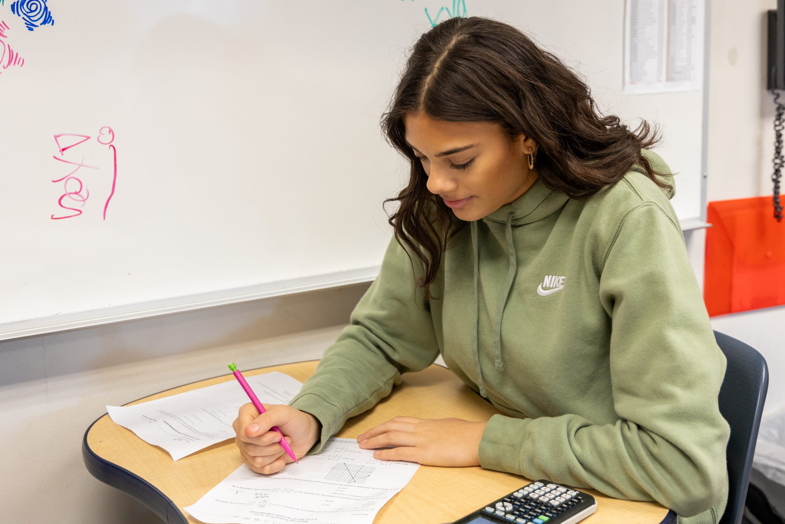 A high school student works diligently in class.