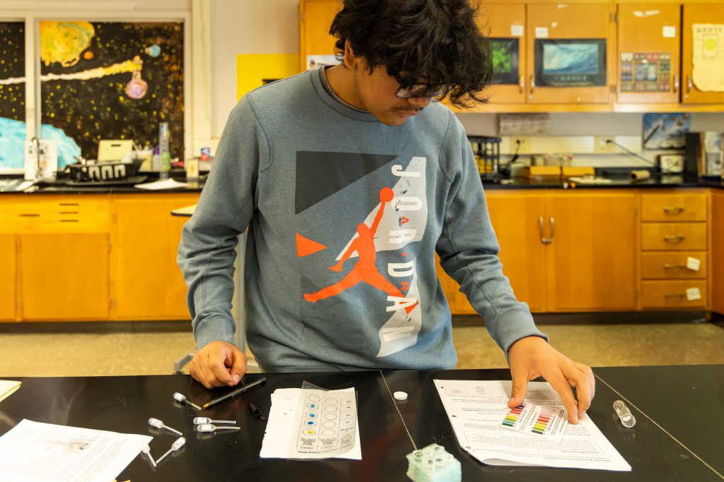 A high school student works diligently in class.