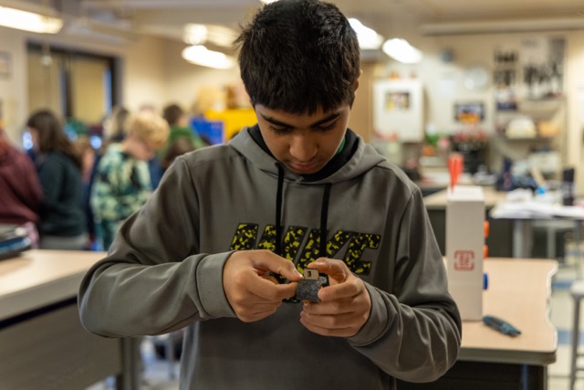 A student works on building a robotic hand.