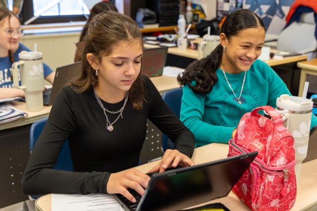 Two middle school students work in class.