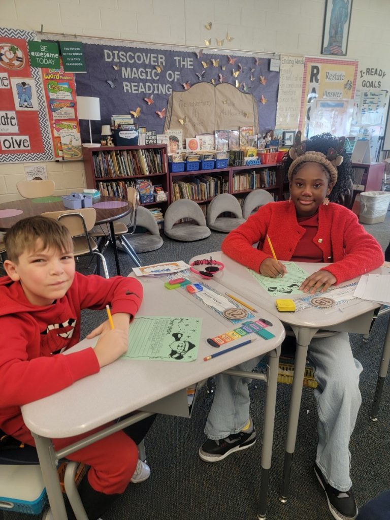 Two happy elementary children writing letters to santa.